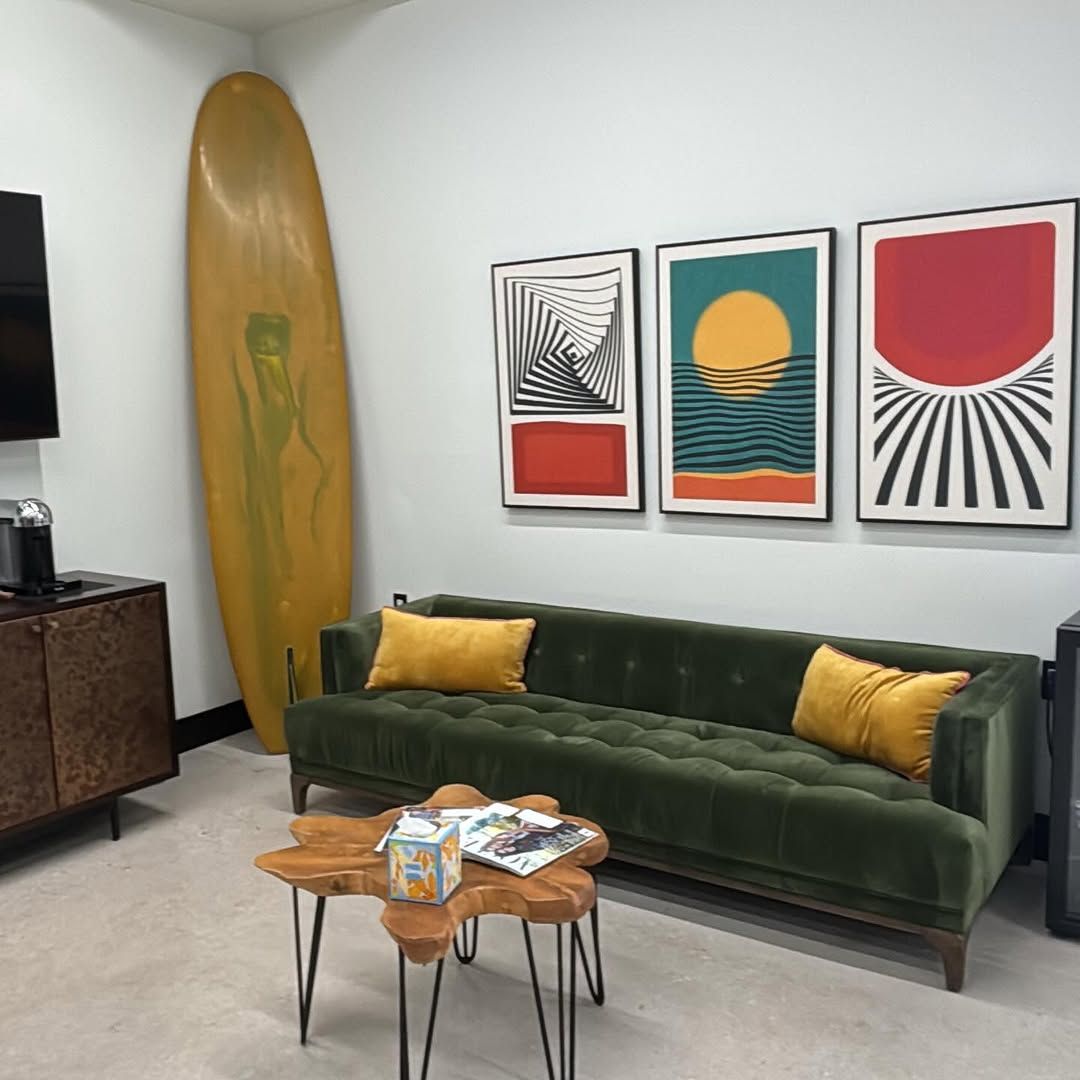 The lounge at Salon 80 West: green velvet sofa, vintage surfboard and mid-century art